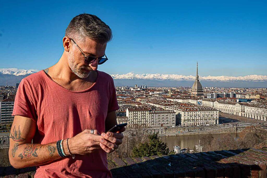 Photo of Rob, the photographer of this website posing at Monte dei Cappuccini in Turin. You can see the city and the Alps in the background. 