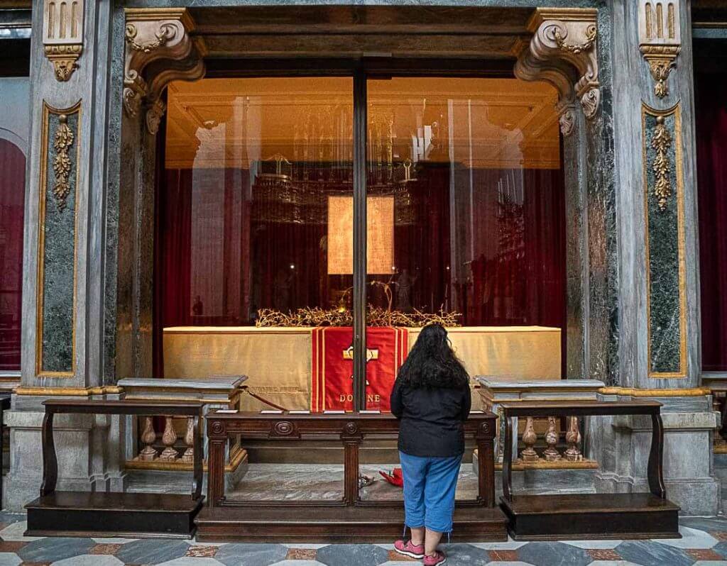 Photo of a woman looking at the Holy Shroud house in Turin Cathedral. An important attraction for religious travelers.