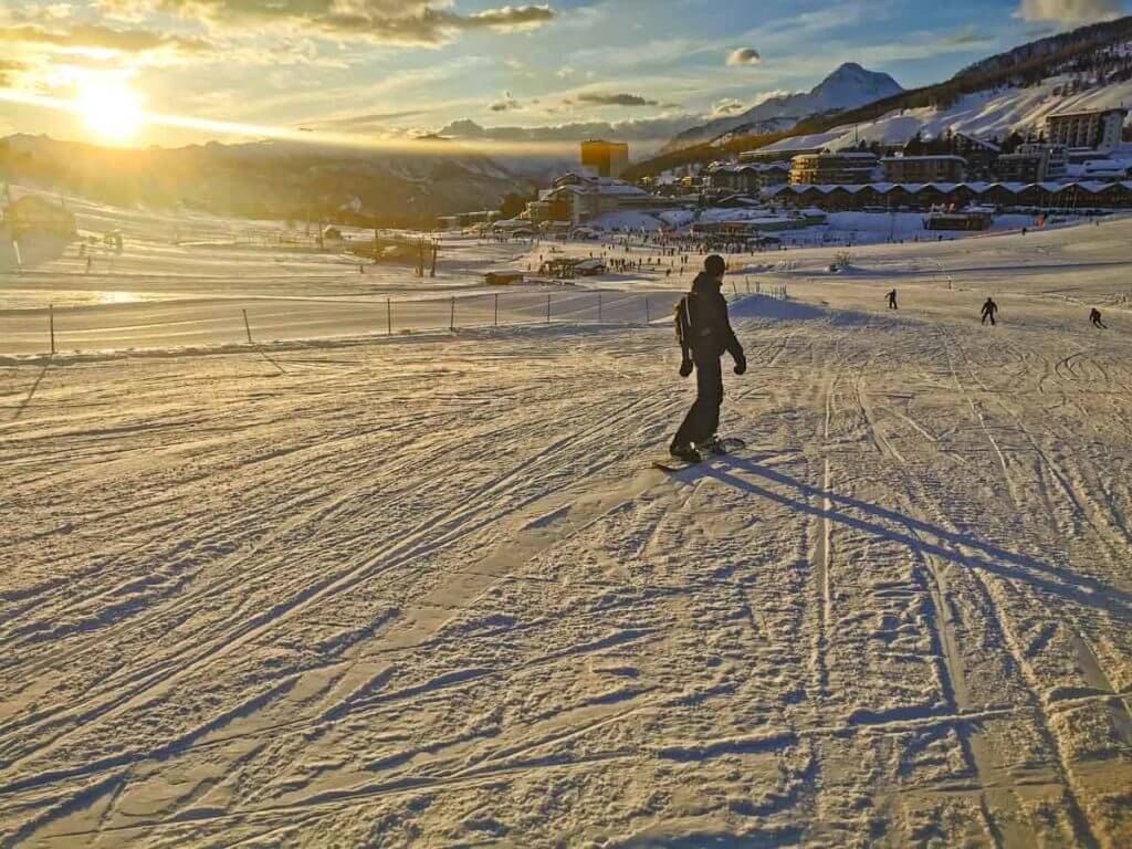 Man snowboarding down on one of the Via Lattea mountains in Sestrière ski resort.