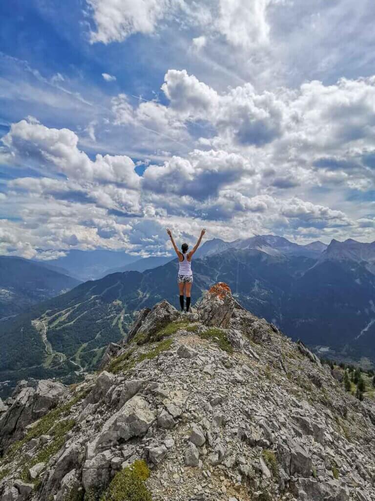 A woman at the top of a mountain in the Italian Alps. 